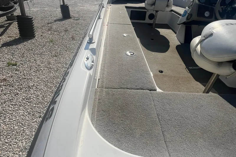 Slide: The Image of 2004 Ranger 618 VS boat interior with gray carpet and seating. - 5