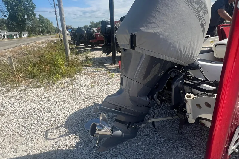 Slide: The Image of 2004 Ranger 618 VS boat engine with cover, parked on gravel near a road. - 9