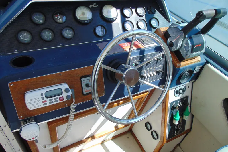Slide: The Image of Dashboard of a 1988 Sea Ray 270 Amberjack boat with steering wheel and controls. - 16