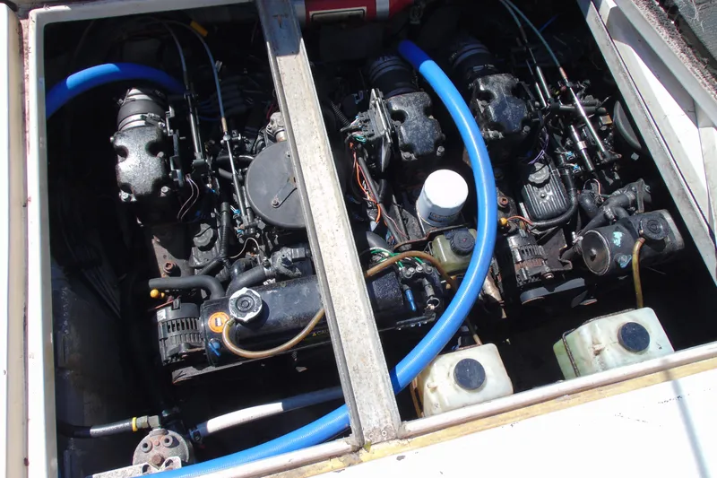Slide: The Image of Engine compartment of a 1988 Sea Ray 270 Amberjack with visible components and blue hoses. - 18