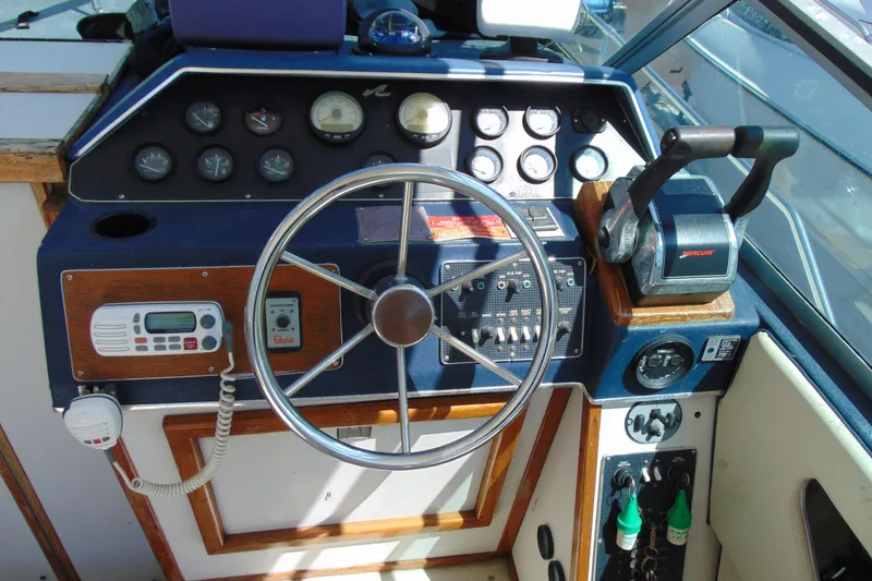 Slide: The Image of 1988 Sea Ray 270 Amberjack boat dashboard with steering wheel and control panel. - 7