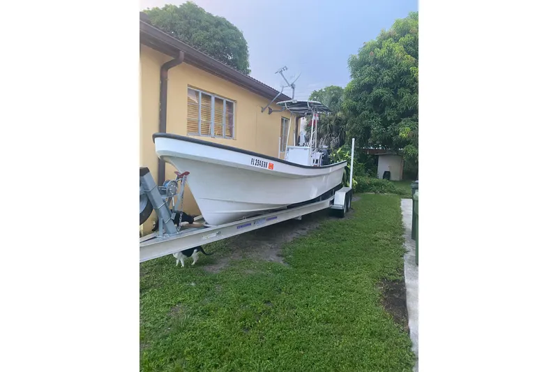 Slide: The Image of 2017 Panga Minsa boat on trailer, parked beside a house under a clear blue sky. - 1