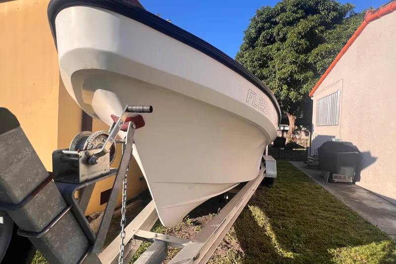 Slide: The Image of 2017 Panga Minsa boat on trailer, parked beside a house, under clear blue sky. - 2