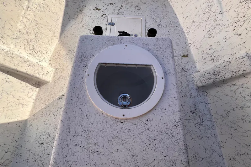 Slide: The Image of 2017 Panga Minsa boat interior with storage compartment and rod holders, under clear blue sky. - 20