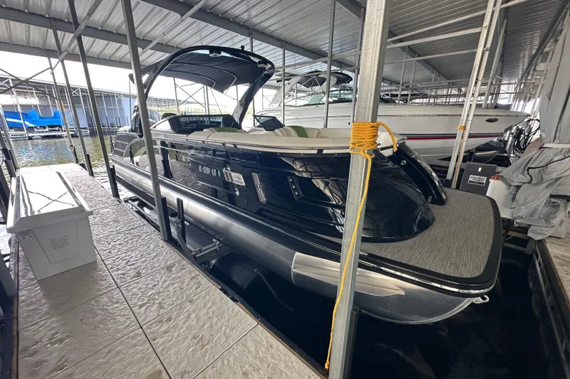 The Image of 2022 Bennington QX 25 Quad Bench pontoon boat docked in a covered marina. - 0