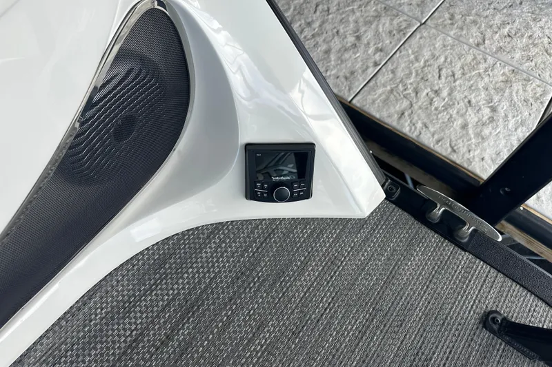 Slide: The Image of 2022 Bennington QX 25 Quad Bench pontoon boat docked in a covered marina. - 18