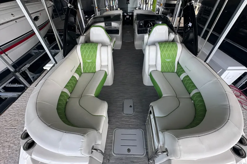 Slide: The Image of 2022 Bennington QX 25 Quad Bench pontoon boat docked in a covered marina. - 19