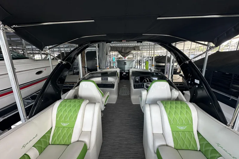 Slide: The Image of 2022 Bennington QX 25 Quad Bench pontoon boat with green and white interior, docked in marina. - 20