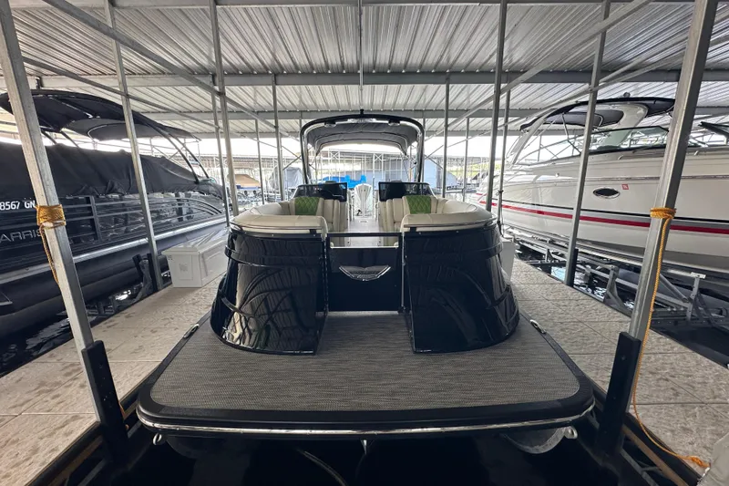 Slide: The Image of 2022 Bennington QX 25 Quad Bench interior with green seating, docked at marina. - 7