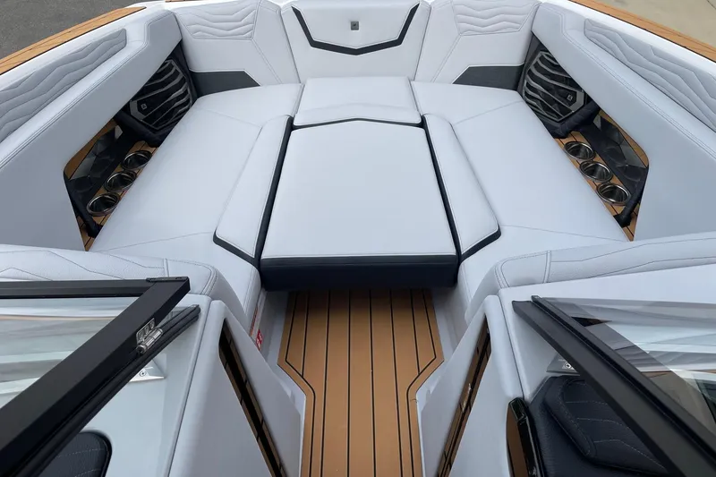 Slide: The Image of 2026 Nautique Super Air Nautique G25 interior with luxurious seating and cup holders. - 11