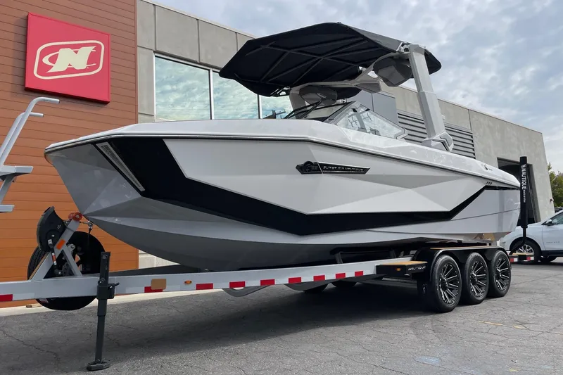 Slide: The Image of 2026 Nautique Super Air Nautique G25 boat on trailer, displayed outdoors. - 2