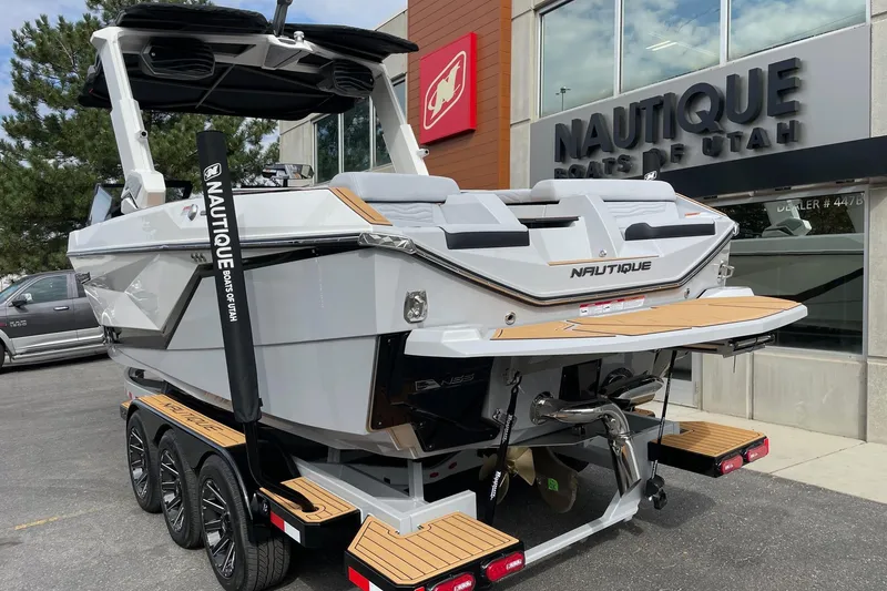 Slide: The Image of 2026 Nautique Super Air Nautique G25 boat displayed at dealership, rear view. - 3