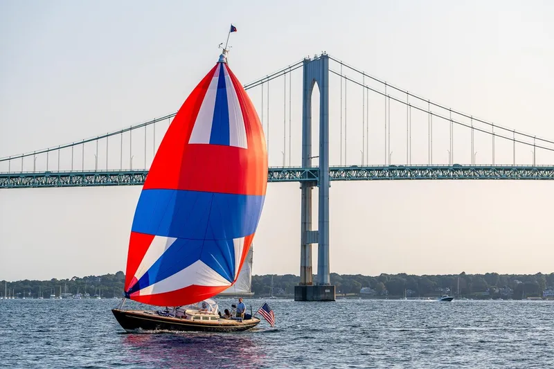 Slide: The Image of 2008 Morris Yachts M36 sailing with colorful spinnaker near a large suspension bridge. - 9