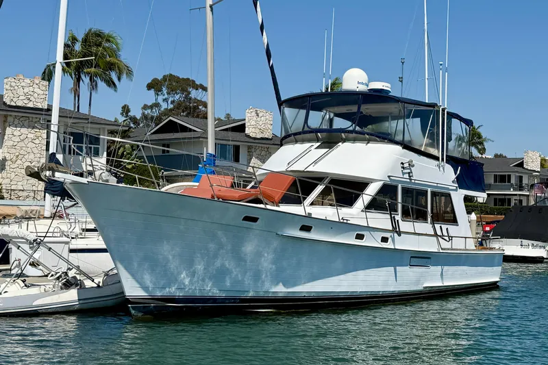 Slide: The Image of 1991 Kong & Halvorsen Island Gypsy yacht docked in a marina, surrounded by palm trees. - 2