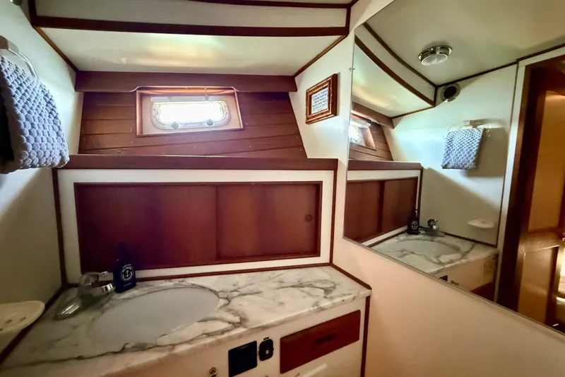 Slide: The Image of Luxurious 1991 Kong & Halvorsen Island Gypsy yacht bathroom with marble countertop and wooden accents. - 20
