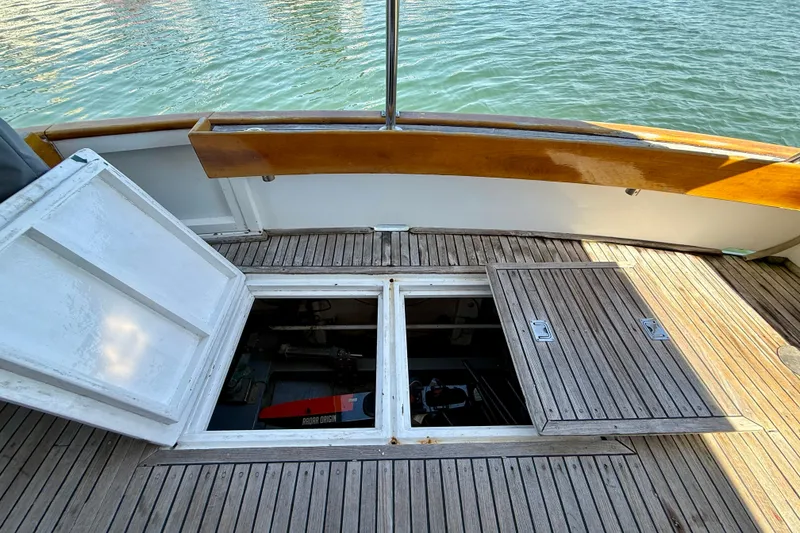 Slide: The Image of 1991 Kong & Halvorsen Island Gypsy boat deck with open hatch, revealing storage compartment. - 26