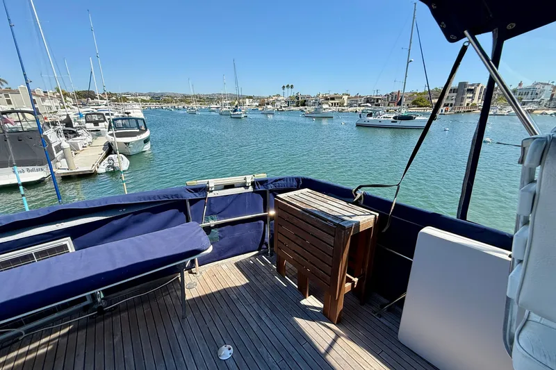 Slide: The Image of 1991 Kong & Halvorsen Island Gypsy yacht deck with marina view, featuring wooden table and seating. - 37