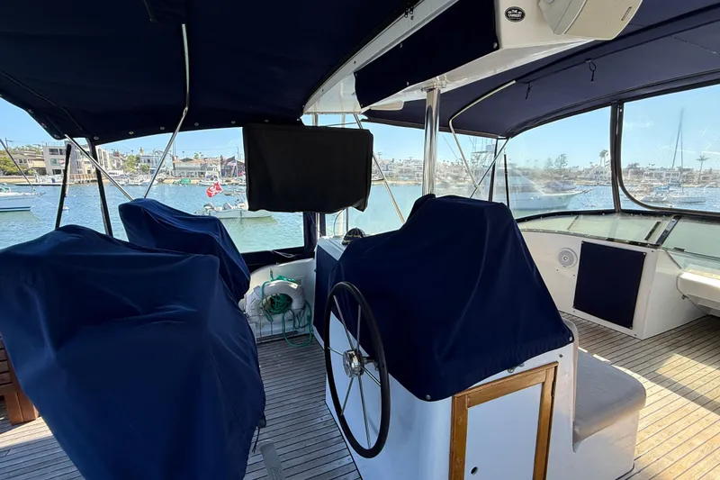 Slide: The Image of 1991 Kong & Halvorsen Island Gypsy yacht interior with covered seating and steering wheel. - 54