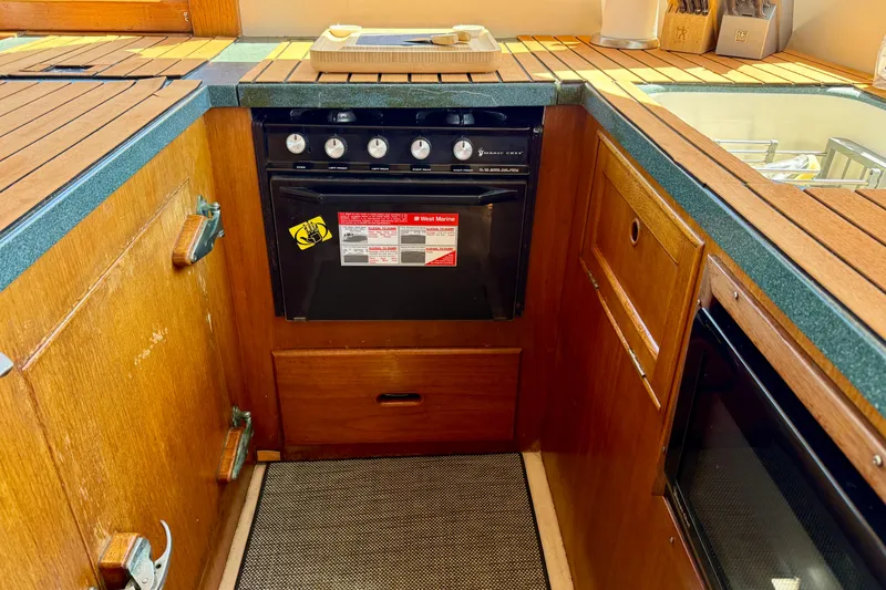 Slide: The Image of 1991 Kong & Halvorsen Island Gypsy yacht kitchen with wooden cabinetry and stove. - 9