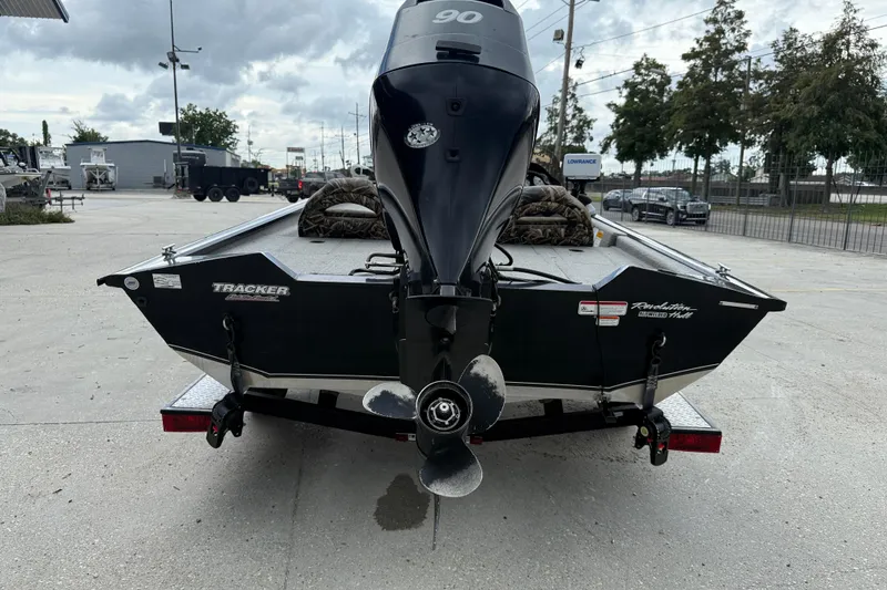 Slide: The Image of 2011 Bass Tracker PRO TEAM 190 TX boat with outboard motor, parked outdoors. - 6