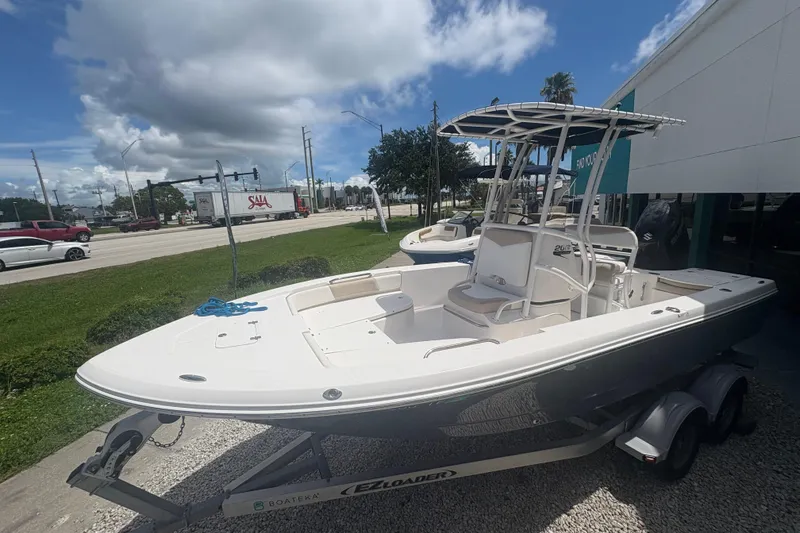 Slide: The Image of 2022 Robalo 206 Cayman boat on trailer, parked outdoors under a cloudy sky. - 4