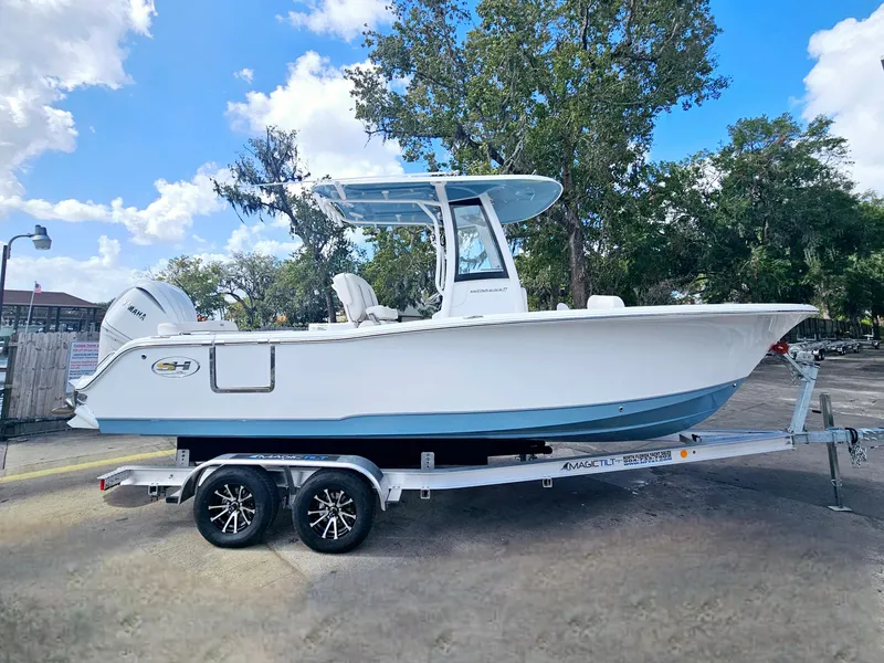 Slide: The Image of 2025 Sea Hunt Ultra 239 SE boat on trailer, parked outdoors under blue sky. - 10