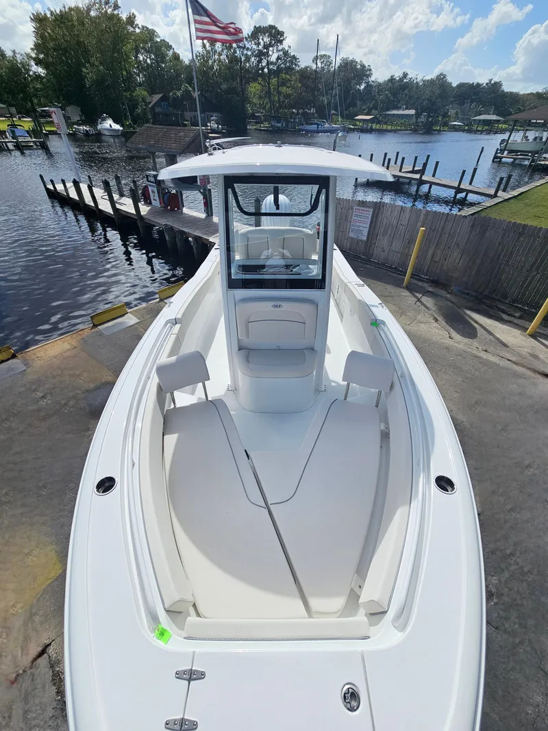 Slide: The Image of 2025 Sea Hunt Ultra 239 SE boat at dock, featuring spacious deck and sleek design. - 16