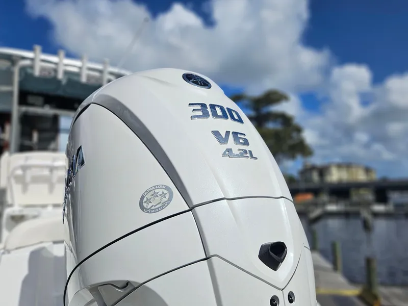 Slide: The Image of 2025 Sea Hunt Ultra 239 SE with Yamaha 300 V6 4.2L engine, docked by water. - 2