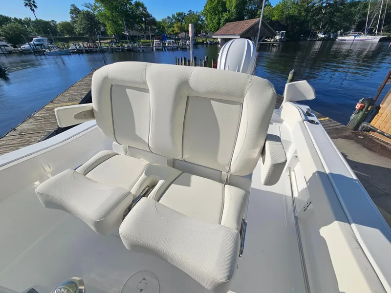 Slide: The Image of 2025 Sea Hunt Ultra 239 SE boat with comfortable seating at a dockside location. - 20