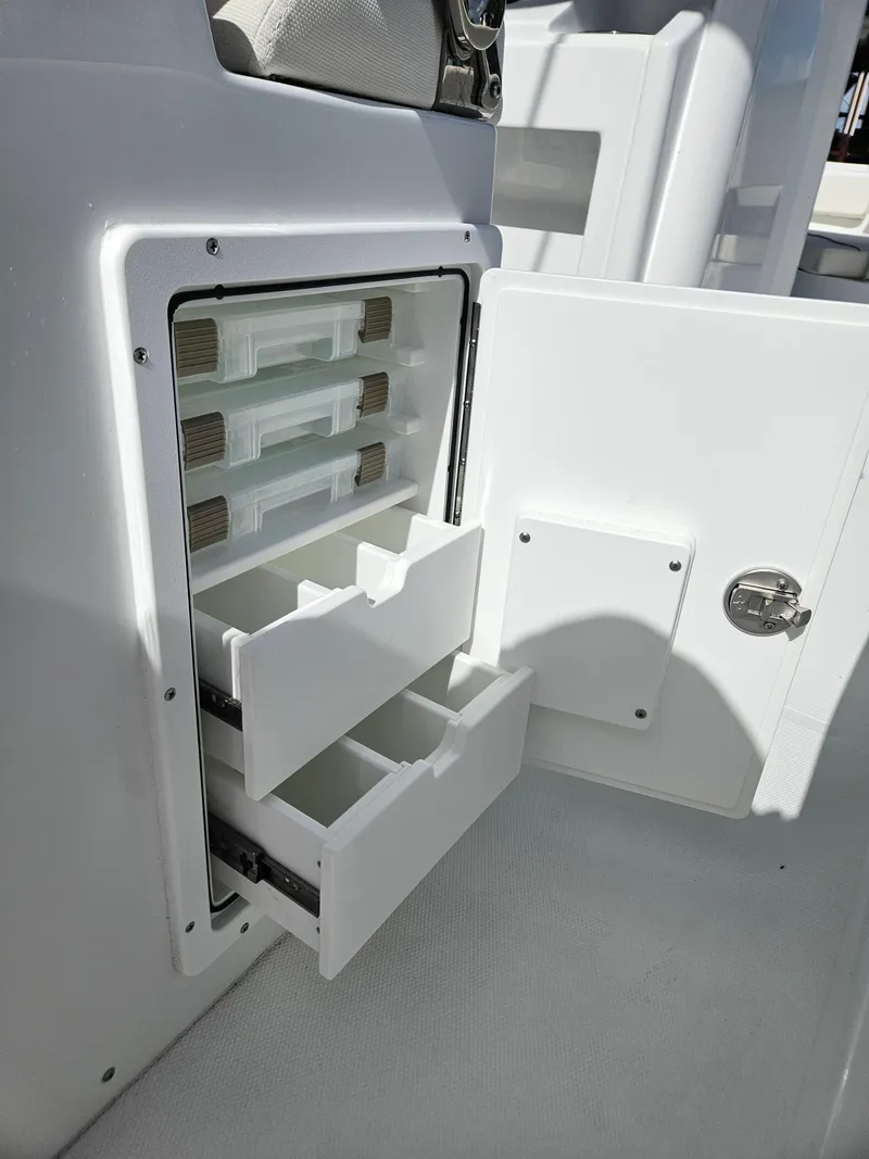 Slide: The Image of 2025 Sea Hunt Ultra 239 SE boat storage compartment with open drawers. - 25
