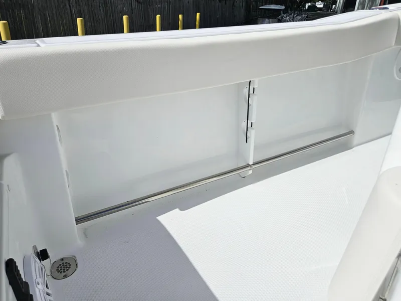 Slide: The Image of 2025 Sea Hunt Ultra 239 SE boat interior with white seating and storage compartment. - 26