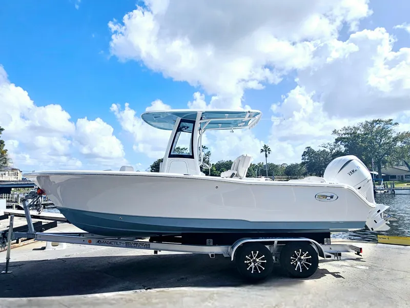 Slide: The Image of 2025 Sea Hunt Ultra 239 SE boat on trailer under blue sky. - 4