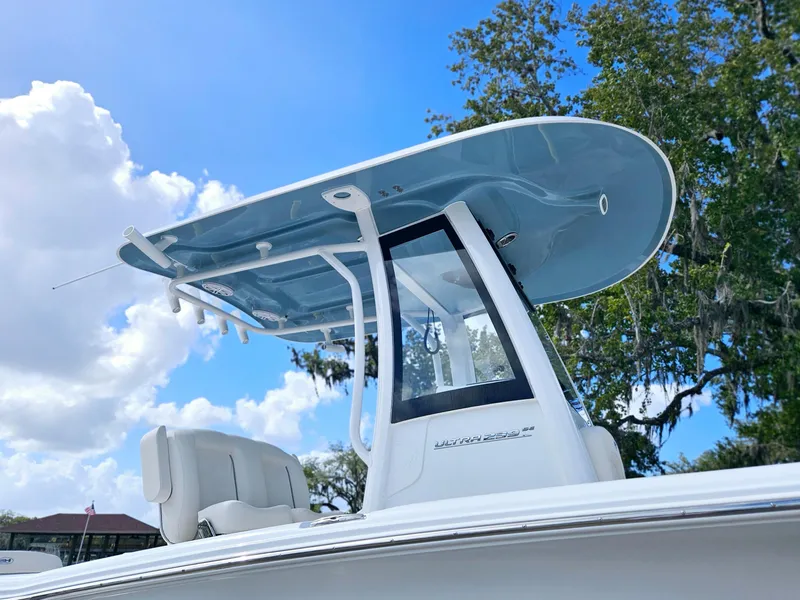 Slide: The Image of 2025 Sea Hunt Ultra 239 SE boat with sleek T-top against blue sky. - 12