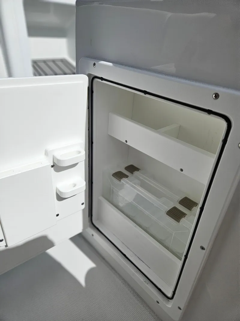 Slide: The Image of Open storage compartment on 2025 Sea Hunt Ultra 239 SE boat, showcasing interior shelves. - 24