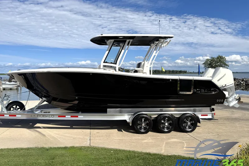 The Image of 2025 Robalo R270 Center Console boat on trailer by the waterfront. - 0