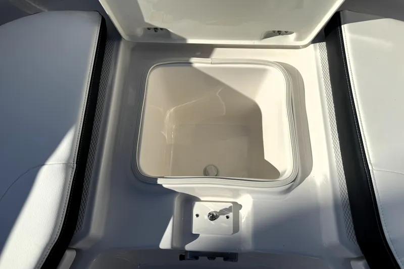 Slide: The Image of 2025 Robalo R270 Center Console storage compartment, open and empty, with white interior. - 18