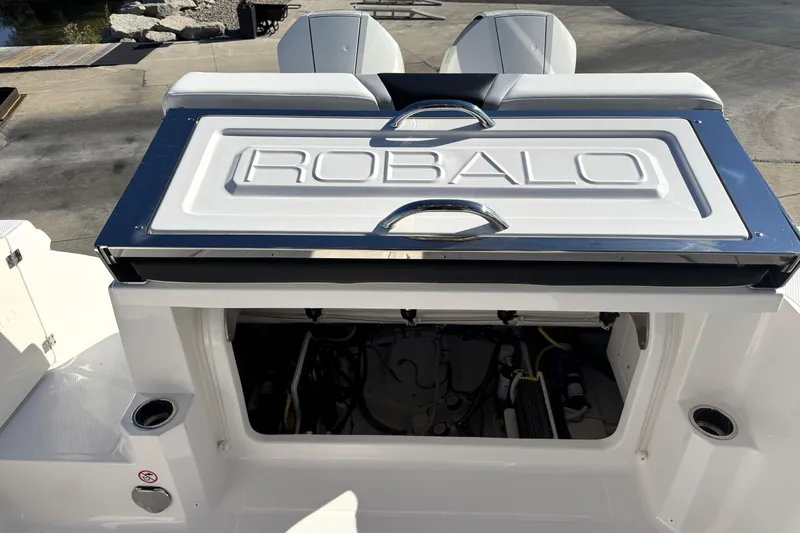 Slide: The Image of 2025 Robalo R270 Center Console boat engine compartment with branded cover. - 20