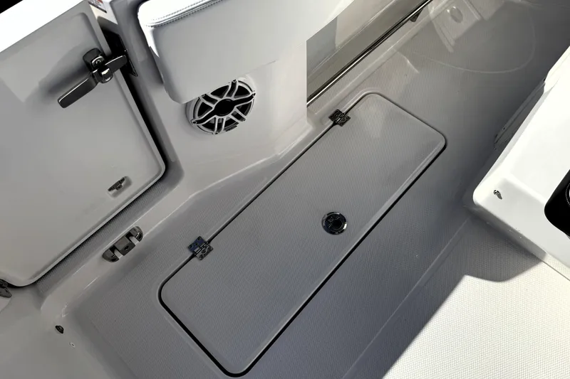 Slide: The Image of 2025 Robalo R270 Center Console boat interior with storage compartment and speaker. - 23
