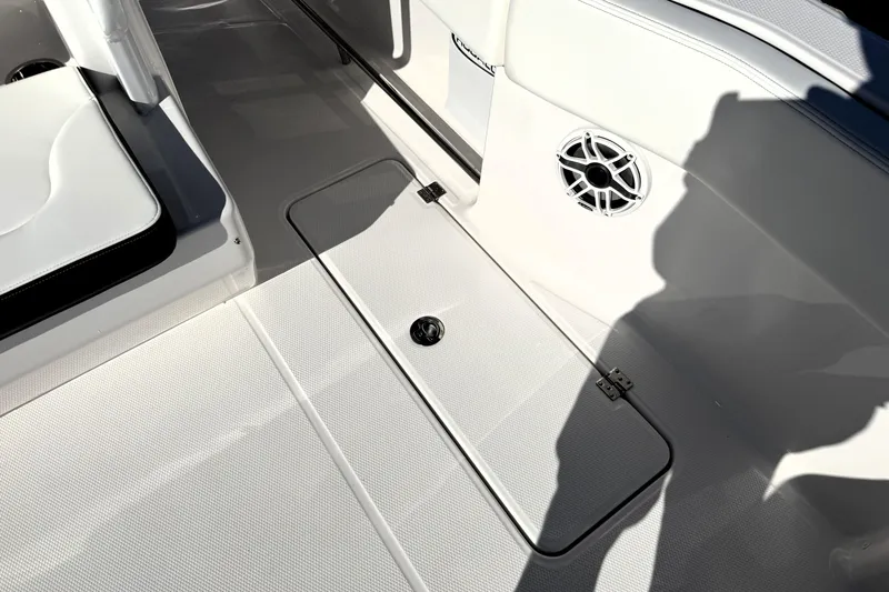 Slide: The Image of 2025 Robalo R270 Center Console boat interior with storage hatch and speaker. - 24