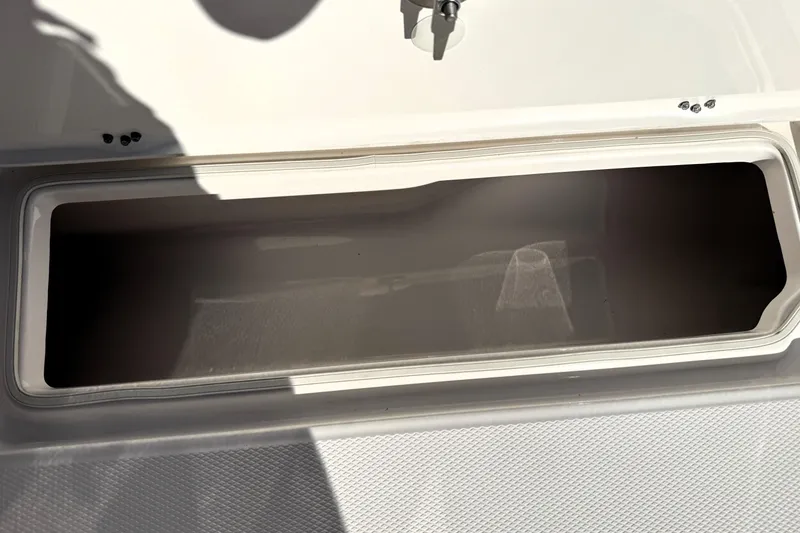 Slide: The Image of 2025 Robalo R270 Center Console storage compartment, open and empty. - 25
