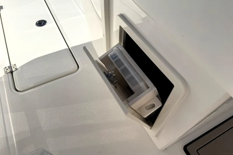 Slide: The Image of 2025 Robalo R270 Center Console storage compartment with open hatch. - 27