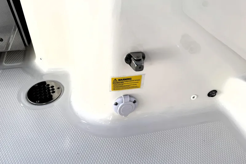 Slide: The Image of 2025 Robalo R270 Center Console boat deck with warning label and fittings. - 29