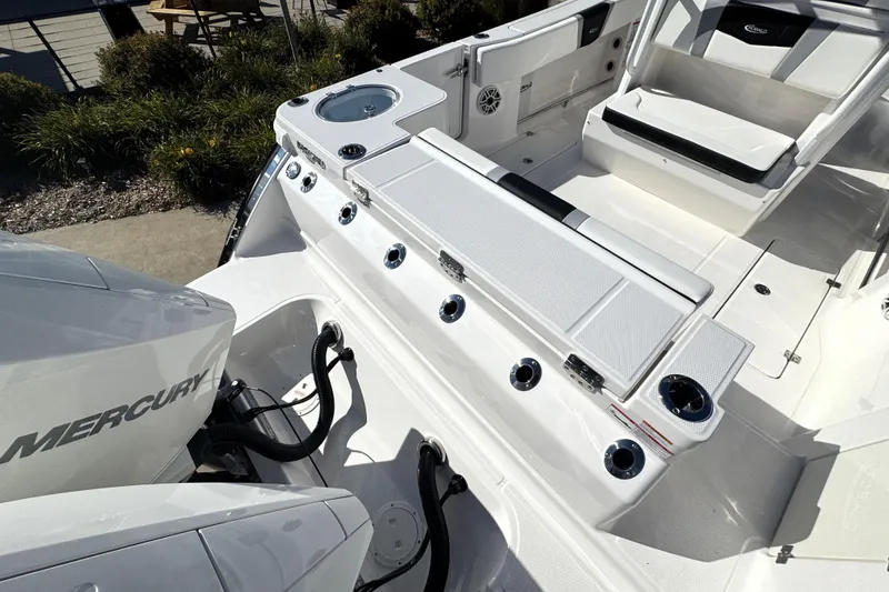 Slide: The Image of 2025 Robalo R270 Center Console boat interior with Mercury engine, featuring seating and fishing rod holders. - 31
