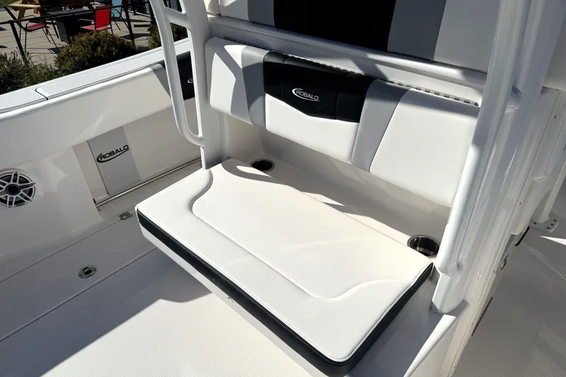 Slide: The Image of 2025 Robalo R270 Center Console boat seating area with cushioned bench and cup holders. - 39