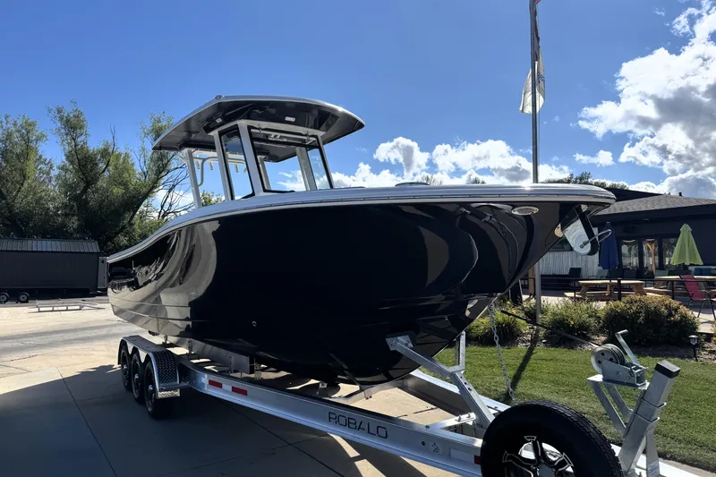 Slide: The Image of 2025 Robalo R270 Center Console boat on trailer under clear blue sky. - 4