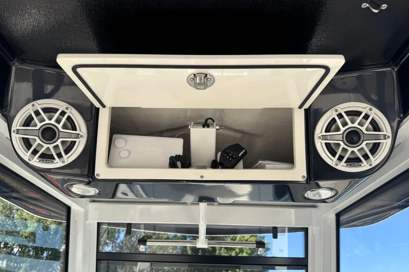 Slide: The Image of 2025 Robalo R270 Center Console storage with speakers and electronic equipment. - 9