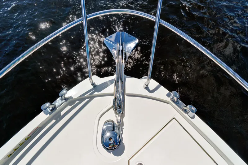 Slide: The Image of Bow view of 2025 Absolute 52 FLY yacht with gleaming chrome details on water. - 24