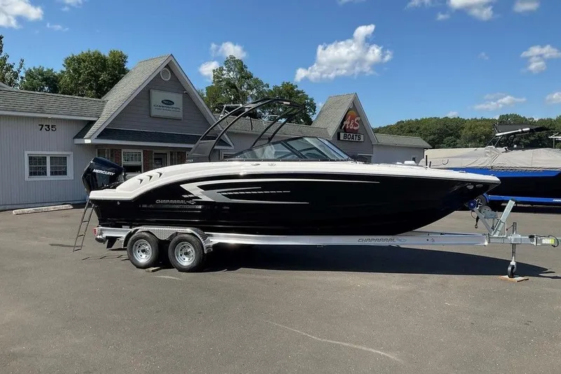 The Image of 2026 Chaparral 23 SSi OB boat on trailer outside dealership under blue sky. - 0