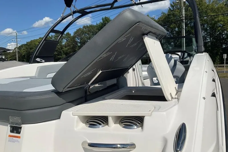 Slide: The Image of 2026 Chaparral 23 SSi OB boat with open storage compartment and sleek seating design. - 20