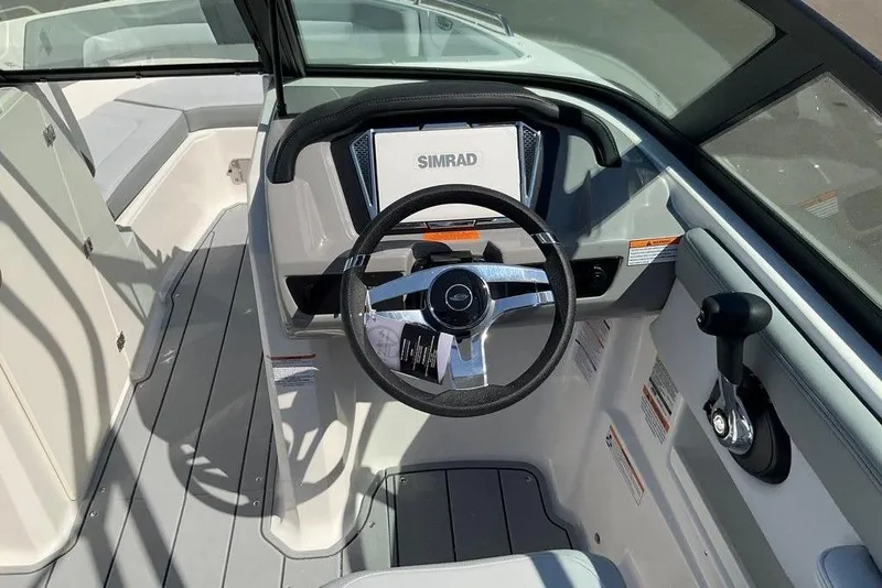 Slide: The Image of 2026 Chaparral 23 SSi OB boat cockpit with steering wheel and Simrad display. - 30